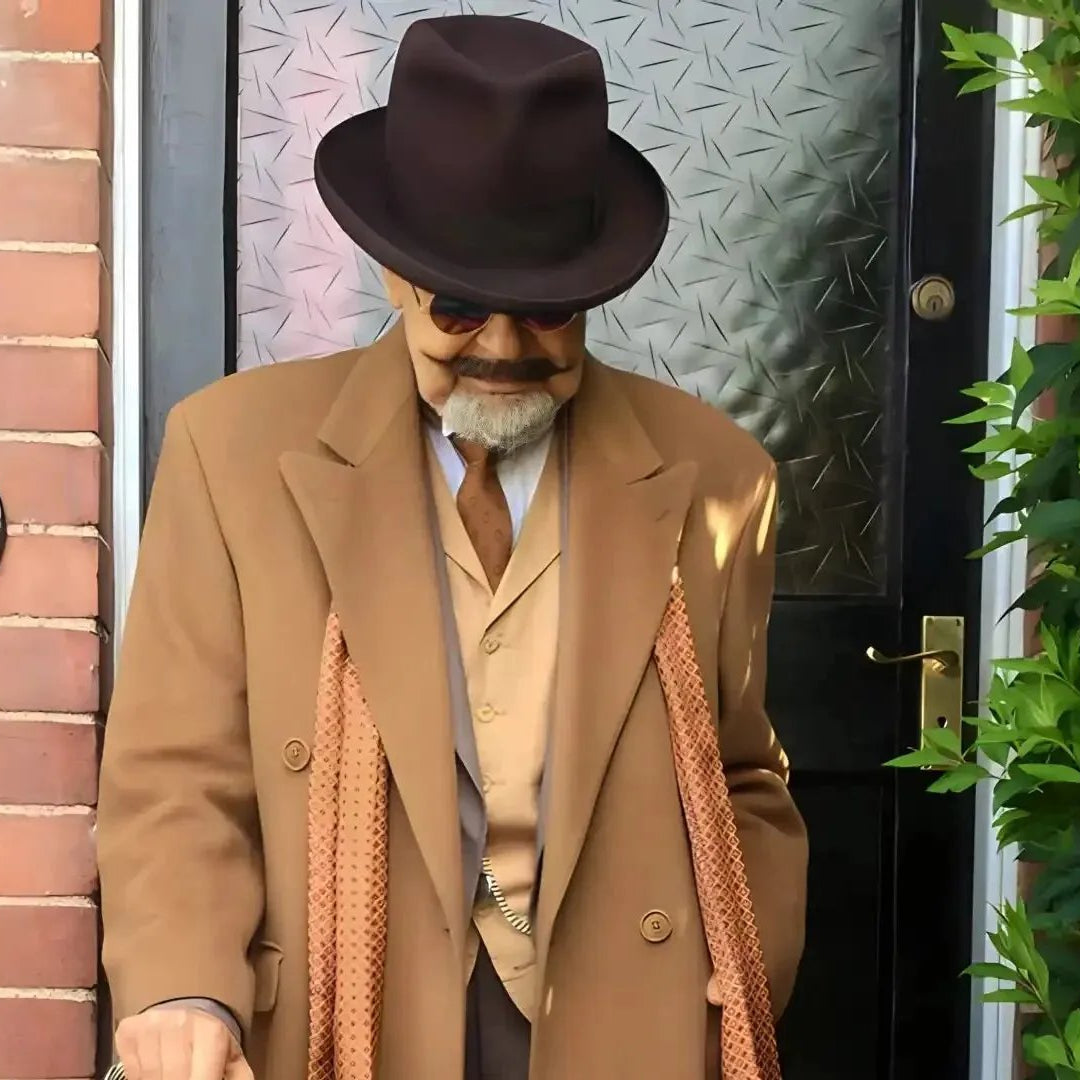 doorstep photo of a well dressed gentleman holding a cane and wearing a beaver homburg fedora